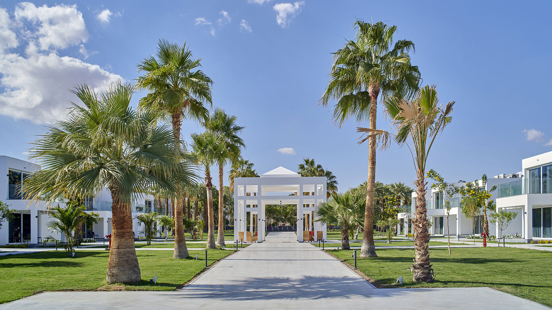 Garden Palm-lined avenue in the gardens of Maritim Jolie Ville Resort & Casino Sharm El Sheikh with modern architecture