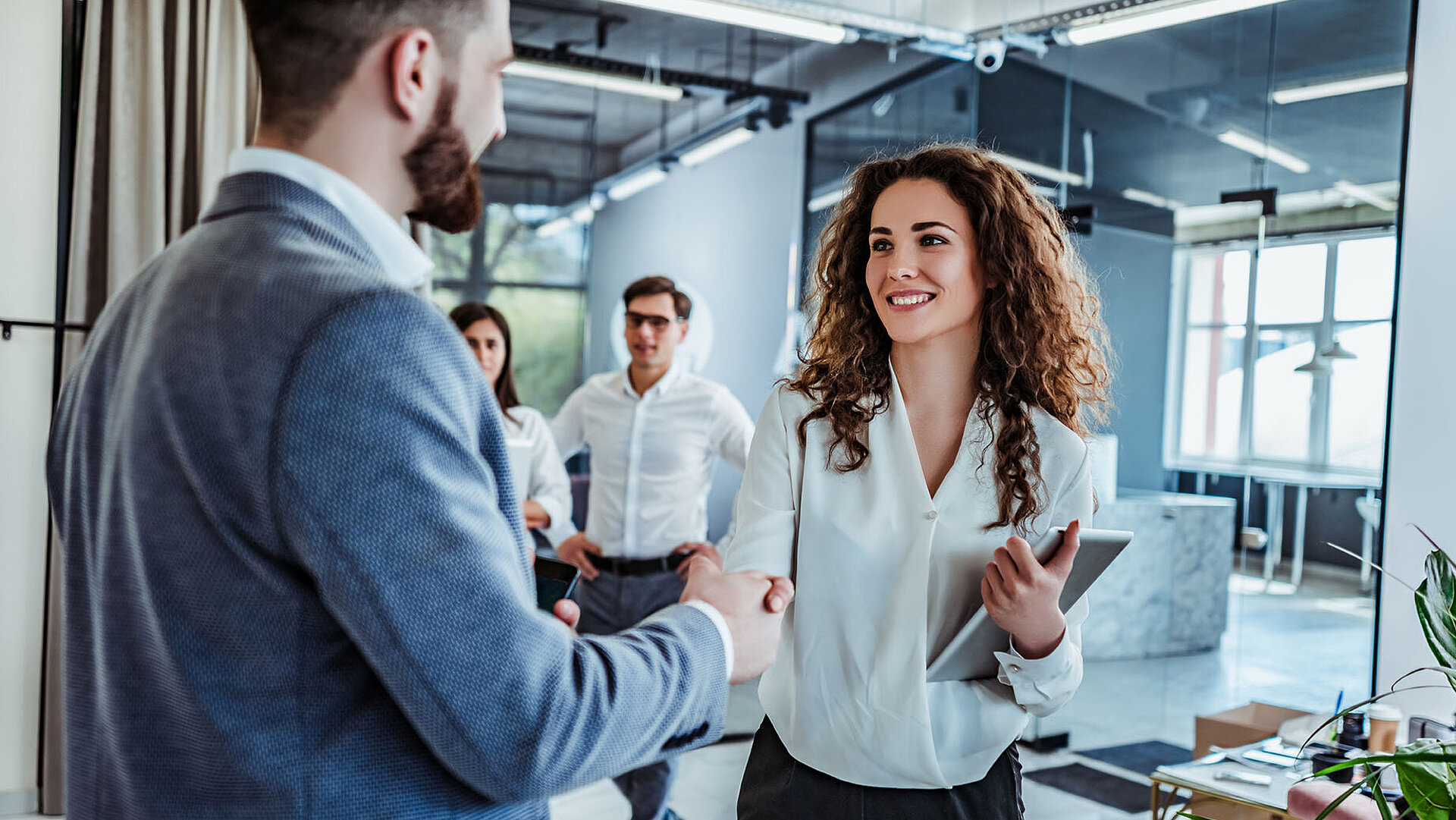 © HBS - AdobeStock.com Geschäftsleute begrüßen sich per Handschlag im modernen Büro